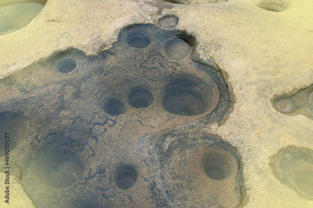 Obraz premium Background image of rocks eroded by river water, grooves and holes. Light fare.