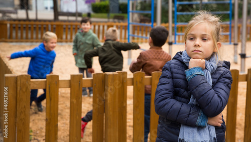 Upset preteen girl standing apart, offended after quarrel with playmates outside