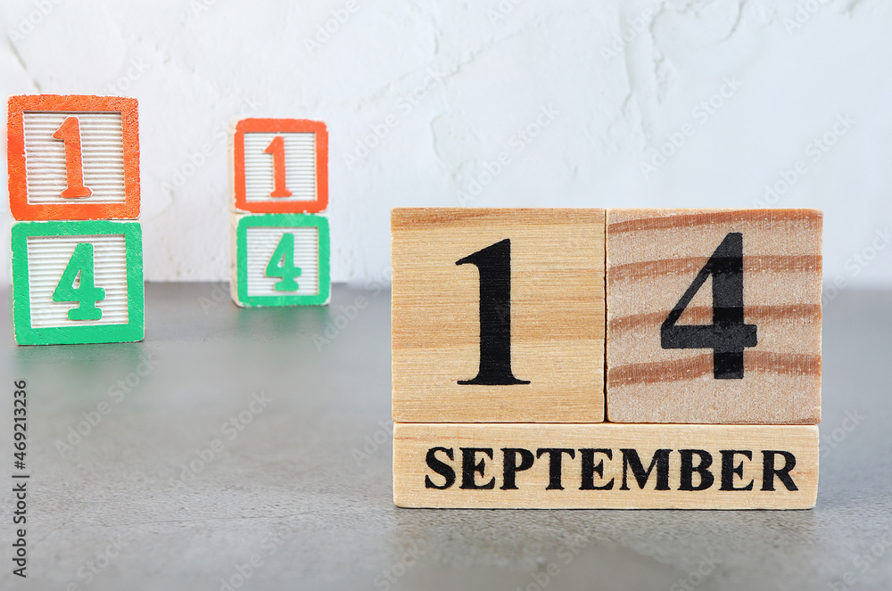 Obraz premium September 14th. Hello September, Cube wooden calendar showing date on 14 September, Wooden calendar with blur objects on background.