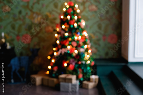 Blurry Christmas background with window and Christmas tree. The Christmas tree is out of focus.