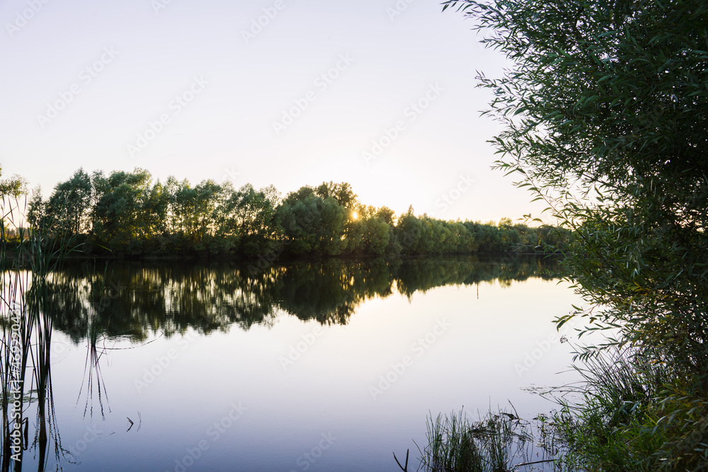 Beautiful smooth lake in sunset lights. Selective focus.
