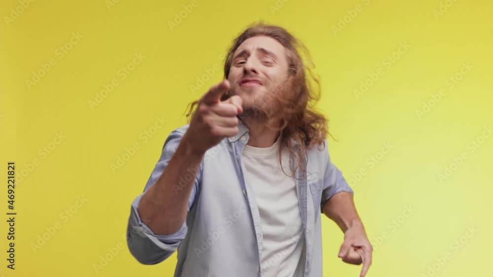 Handsome curly young guy in in casual clothes isolated over yellow background in studio. People sincere emotions, lifestyle concept. Caucasian man look at the camera doing winner gesture, say yeah. Handsome curly young guy in in casual clothes isolated over yellow background in studio. People sincere emotions, lifestyle concept. Caucasian man look at the camera doing winner gesture, say yeah.