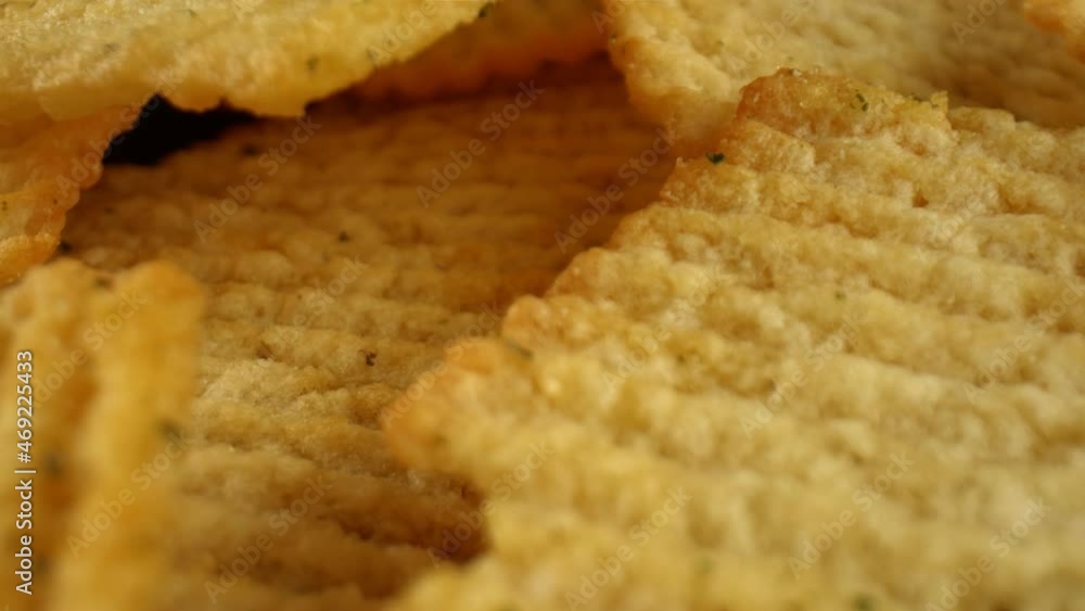 Macro shot of large salted potato chips. Fast food, semi-finished products. Products for rapid hunger quenching with a high content of starch. High quality. 4k footage. Macro shot of large salted potato chips. Fast food, semi-finished products. Products for rapid hunger quenching with a high content of starch. High quality. 4k footage.