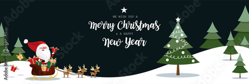 Santa Claus carries gift boxes on a sleigh with a herd of reindeer and Christmas tree in pine tree forest on snowy hill and dark sky with We wish you a Merry Christmas and a Happy New Year text.