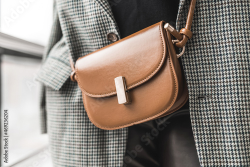 elegant stylish detailed brown handbag in a lady in a beautiful new jacket.