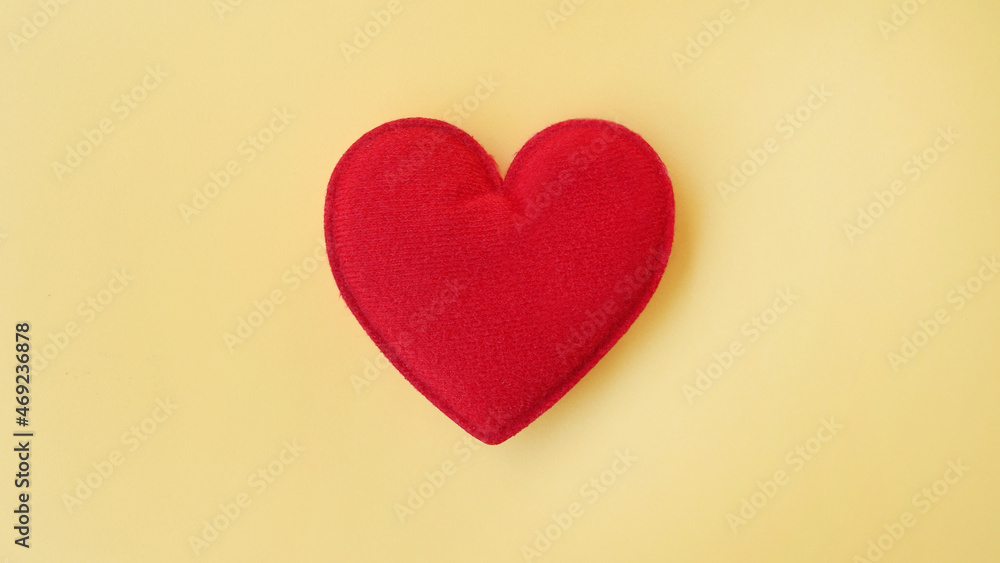 close up of red heart on yellow background