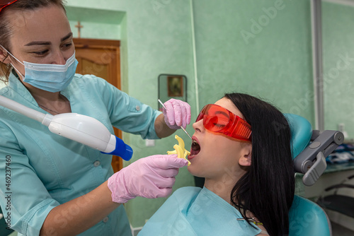 Dentist preparing for whitening procedure with a woman patient