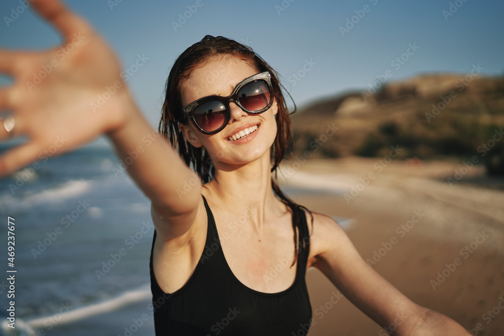 cheerful woman in a black swimsuit walking along the beach tropics summer cheerful woman in a black swimsuit walking along the beach tropics summer