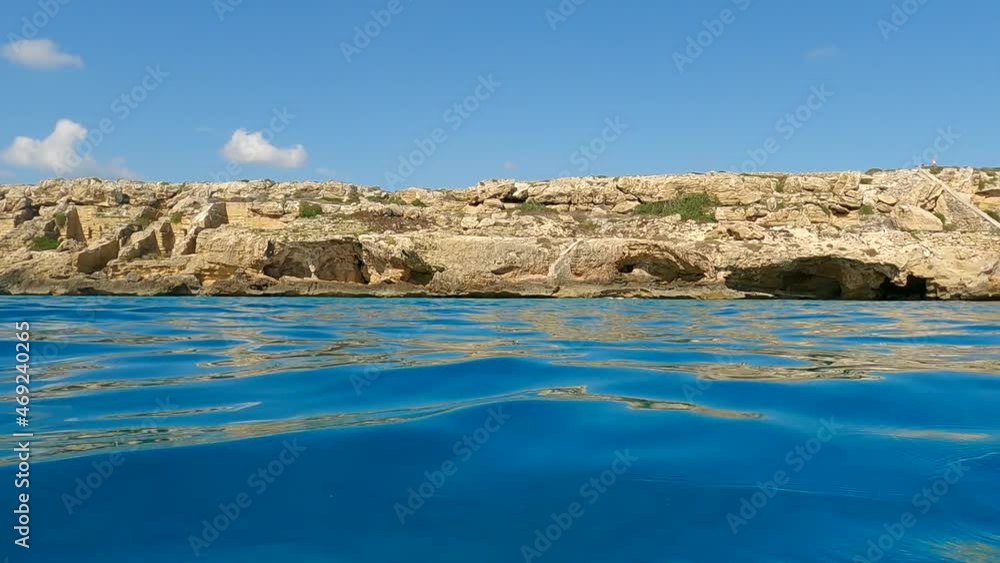 Extreme Low-angle sea-level view from sailing boat of Favignana island coastline in Sicily, Italy. Slow-motion Extreme Low-angle sea-level view from sailing boat of Favignana island coastline in Sicily, Italy. Slow-motion