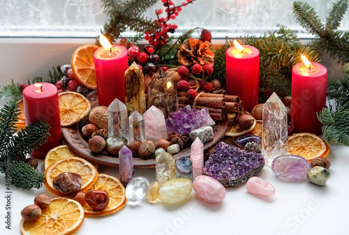Gemstones crystals, candles and natural winter decor on windowsill. Witchcraft esoteric Ritual with energy healing minerals. soul relax concept. Christmas, Magical Winter Solstice