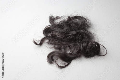 A lock of black hair on a white surface photo