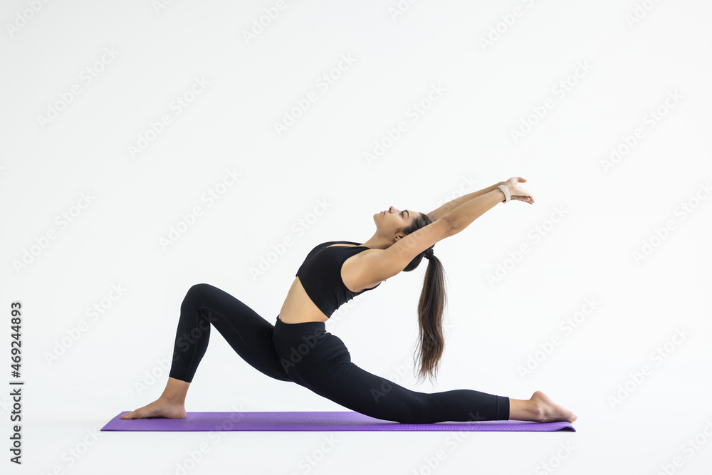 young woman yoga posing isolated over white studio background