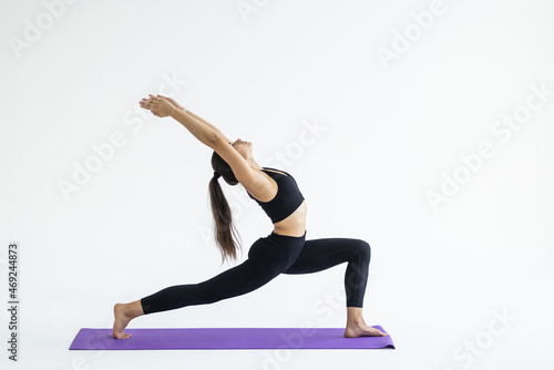 Sporty young woman doing yoga practice isolated on white background. Concept of healthy life and natural balance between body and mental development
