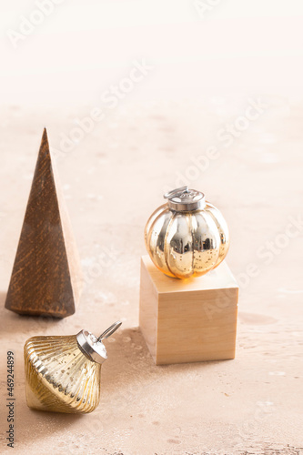 Modern Christmas still life. Wooden tree, bintage gold balls on Podium on  beige background photo