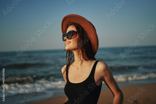 pretty woman in hat walking on the beach ocean travel