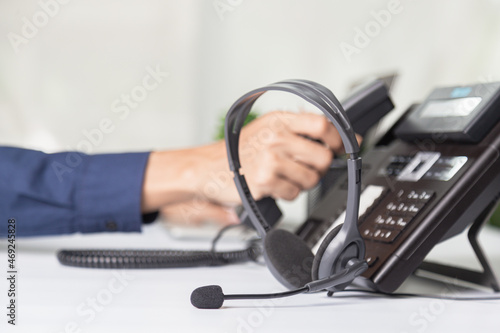 Call center staff man hand point to press the button number on the phone office desk , Communication support, call center and customer service help desk. for (call center) concept