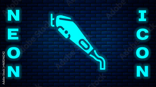 Glowing neon Electrical hair clipper or shaver icon isolated on brick wall background. Barbershop symbol. Vector
