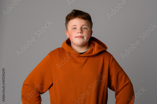 Teenager boy wearing casual clothes standing over gray isolated background, happy face, looking at the camera