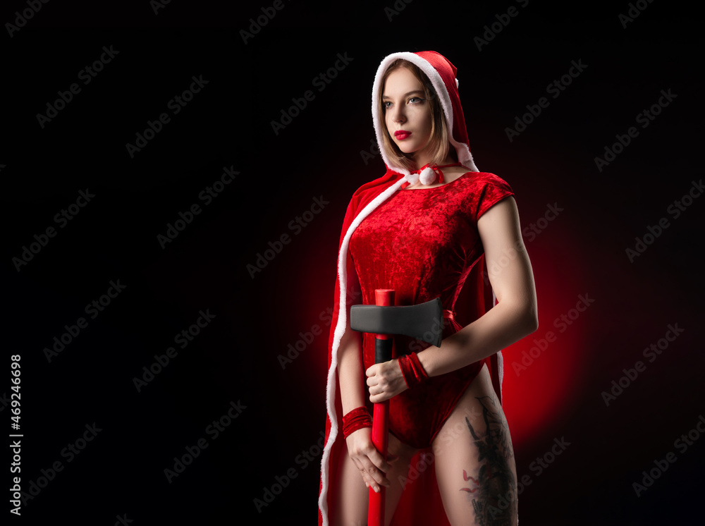 militant girl in a Christmas red Santa Claus cape with an axe in her hands