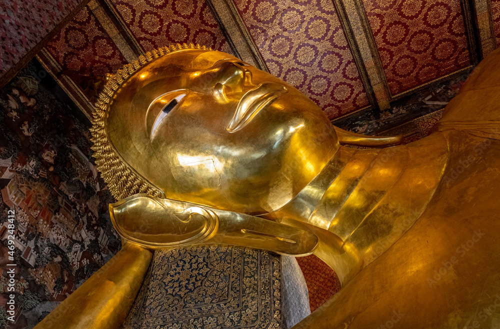 One of the world's largest reclining Buddha statues at the Wat Pho Buddhist Temple in downtown Bangkok Thailand