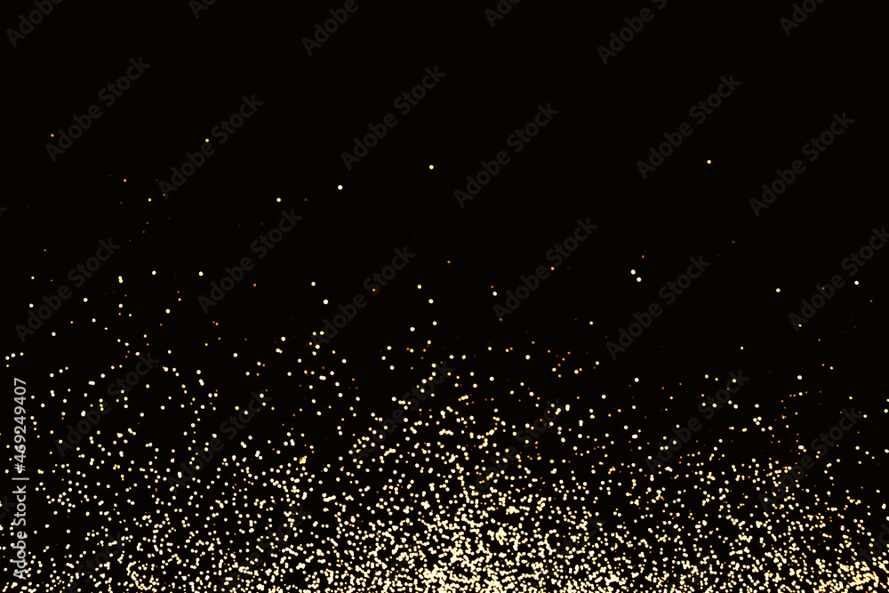 Black festive background of golden glitter lights. Holiday backdrop, selective focus