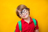 Cheerful positive european teenager boy pupil with backpack ready to study, isolated on yellow background, copy space