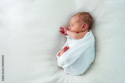 Sweet newborn baby sleeping in white bed, copy space