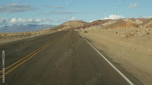 Road trip to Death Valley, Artists Palette drive, California USA. Hitchhiking auto traveling in America. Highway, colorful bare mountains and arid climate wilderness. View from car. Journey to Nevada. © Dogora Sun