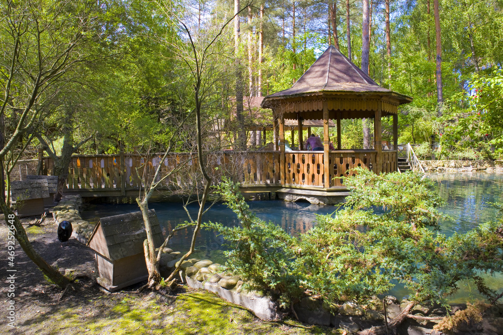 Wooden gazebo near lake in in village