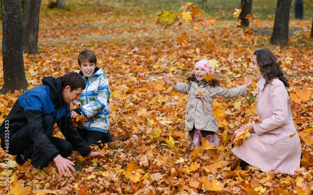 Portrait of a family in an autumn park. Happy people playing with fallen yellow leaves. Portrait of a family in an autumn park. Happy people playing with fallen yellow leaves.