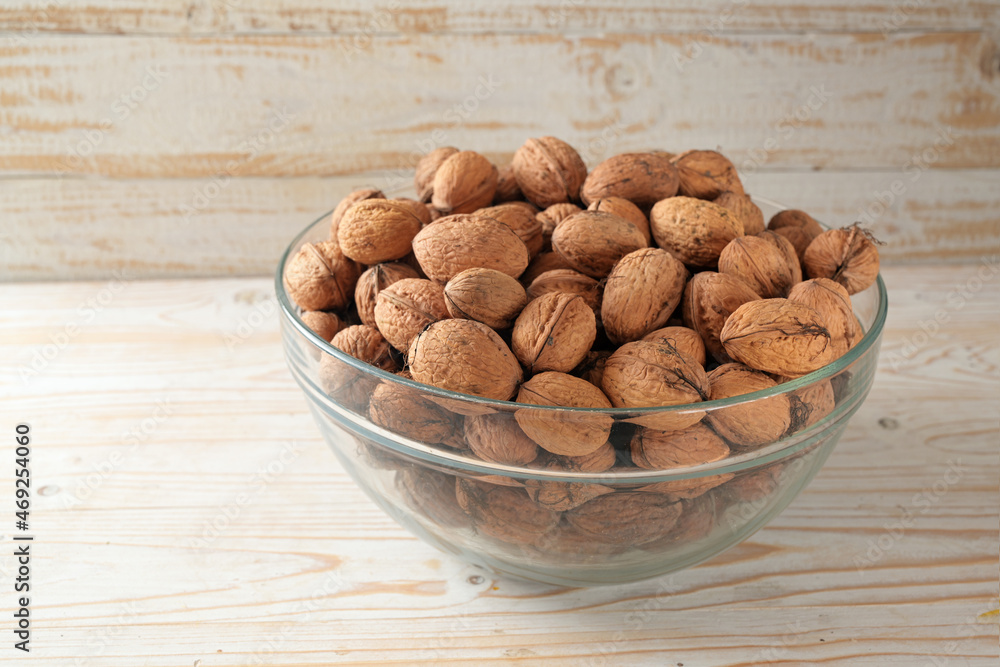 Walnuts in a bowl, freshly harvested in autumn, healthy for the brain with vitamins, unsaturated fatty acids and antioxidants, wooden background, copy space, selected focus Walnuts in a bowl, freshly harvested in autumn, healthy for the brain with vitamins, unsaturated fatty acids and antioxidants, wooden background, copy space, selected focus