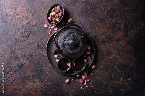 Fotografie Black japanese cast iron teapot with tea of dry roses
