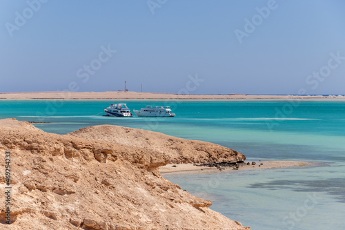 Hurghada, Egypt - September 23 2021: Orange Bay Beach with crystal clear azure water and boat ships with tourists