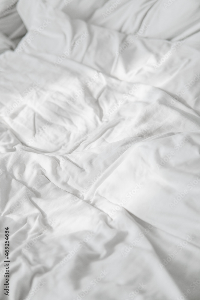 Fototapeta premium Crumpled white linens, bed with white sheet
