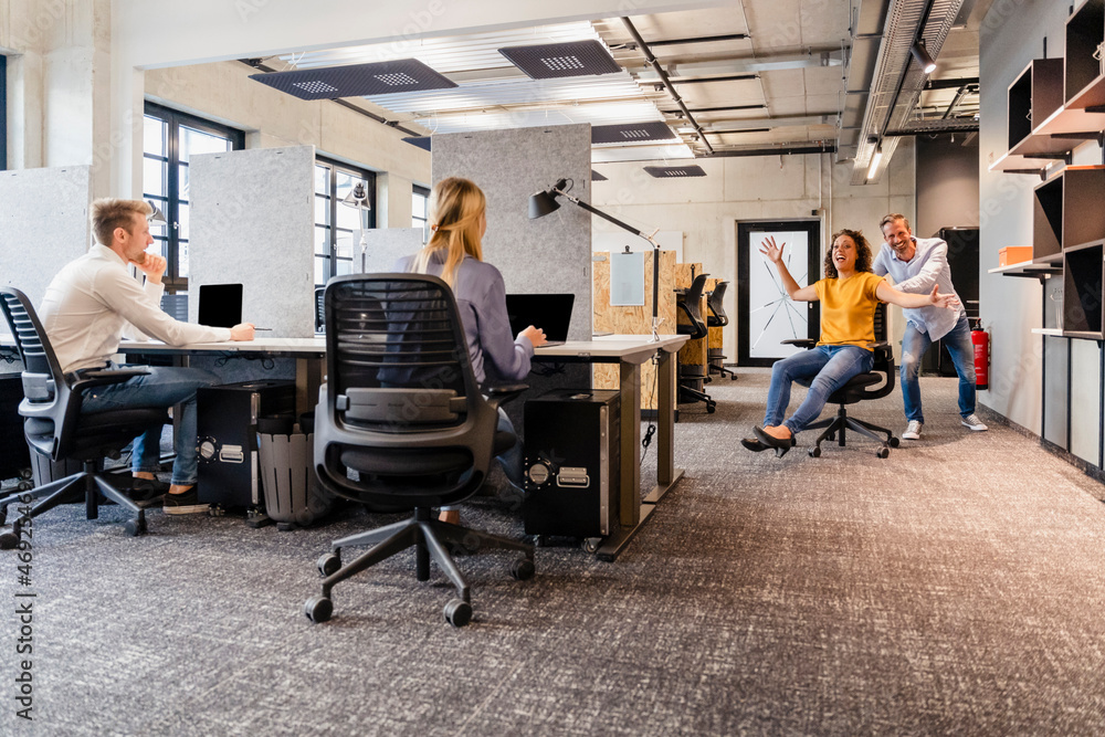 Cheerful coworkers playing in office Cheerful coworkers playing in office