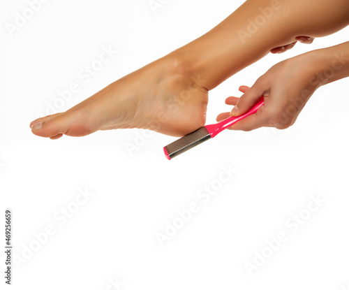 Woman scrubing her feet with a grater
