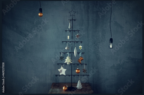 New Year Christmas card. Christmas tree with wooden and metal decorations on the background of a concrete wall in an industrial and loft style.