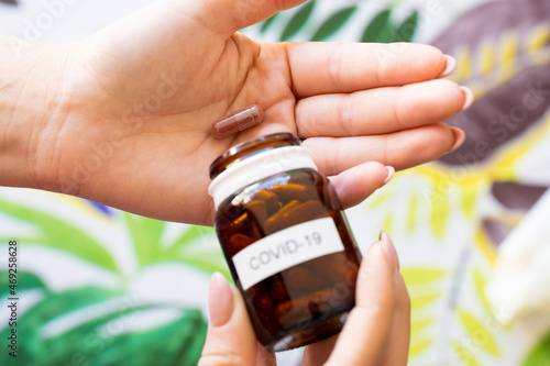 Εκτύπωση καμβά Top view, a girl is taking an antiviral pill against covid-19