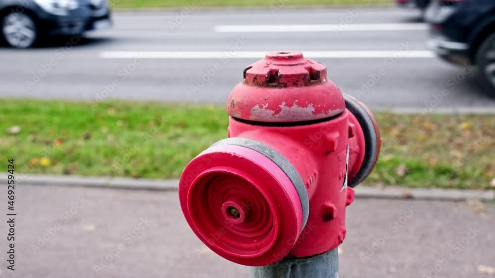 Classic Red Metal Fire Hydrant Located next to Busy Street Classic Red Metal Fire Hydrant Located next to Busy Street