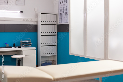 Selective focus on medical bed in empty hospital office with nobody in it during clinical consultation. Modern furniture at workplace. Bright interior of examination room. Health care service