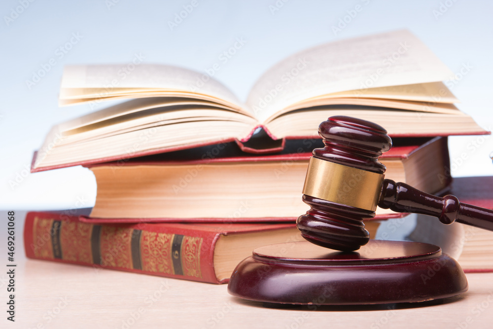 Legal Law and Justice concept - Open law book with a wooden judges gavel on table in a courtroom or law enforcement office. Copy space for text. Legal Law and Justice concept - Open law book with a wooden judges gavel on table in a courtroom or law enforcement office. Copy space for text.