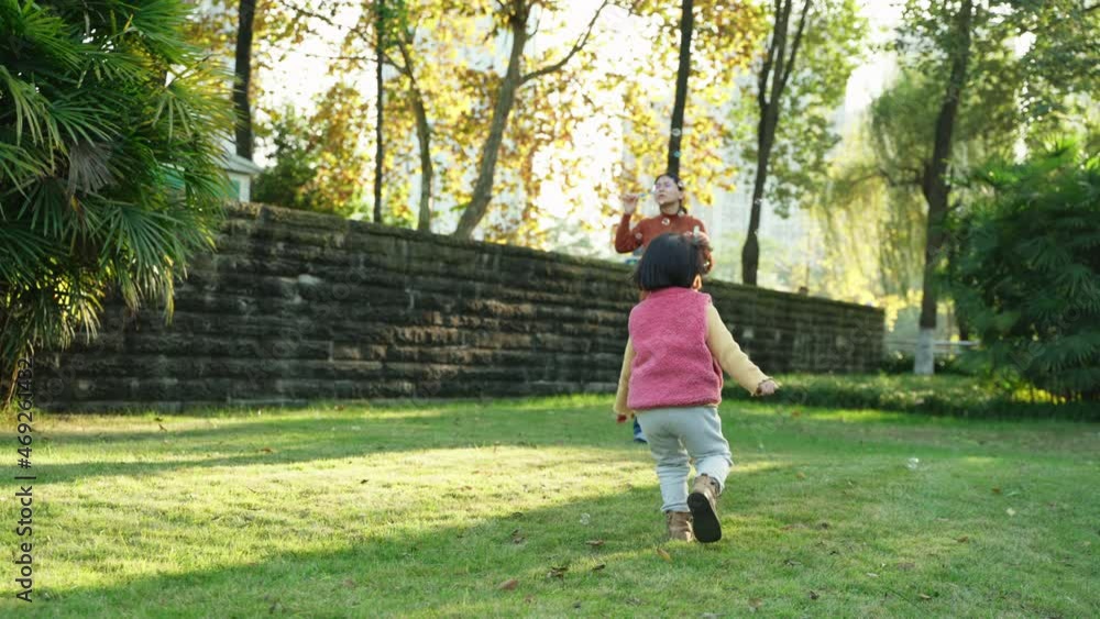 Slow motion happy asian baby girl playing together with mother in the sunny autumn yard lovely child running chasing soap bubbles on the lawn family lifestyles active kid Slow motion happy asian baby girl playing together with mother in the sunny autumn yard lovely child running chasing soap bubbles on the lawn family lifestyles active kid