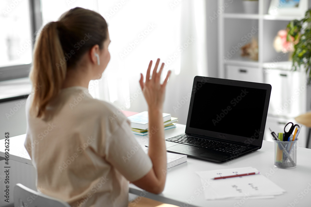 distant education, remote job and people concept - happy smiling female teacher with laptop computer having video call or online class at home office distant education, remote job and people concept - happy smiling female teacher with laptop computer having video call or online class at home office