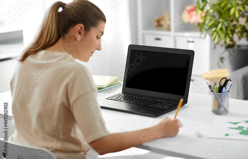 education, online school and distant learning concept - student woman with laptop computer drawing picture at home