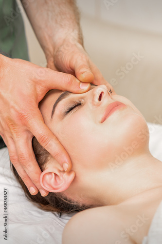 Pretty young caucasian woman receiving a head massage by a male massage therapist in a beauty salon © okskukuruza