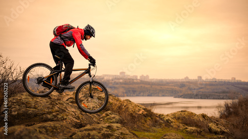 Fototapeta Naklejka Na Ścianę i Meble -  Cyclist Riding the Mountain Bike on the Rocky Trail at Autumn Evening. Extreme Sport and Enduro Cycling Concept.