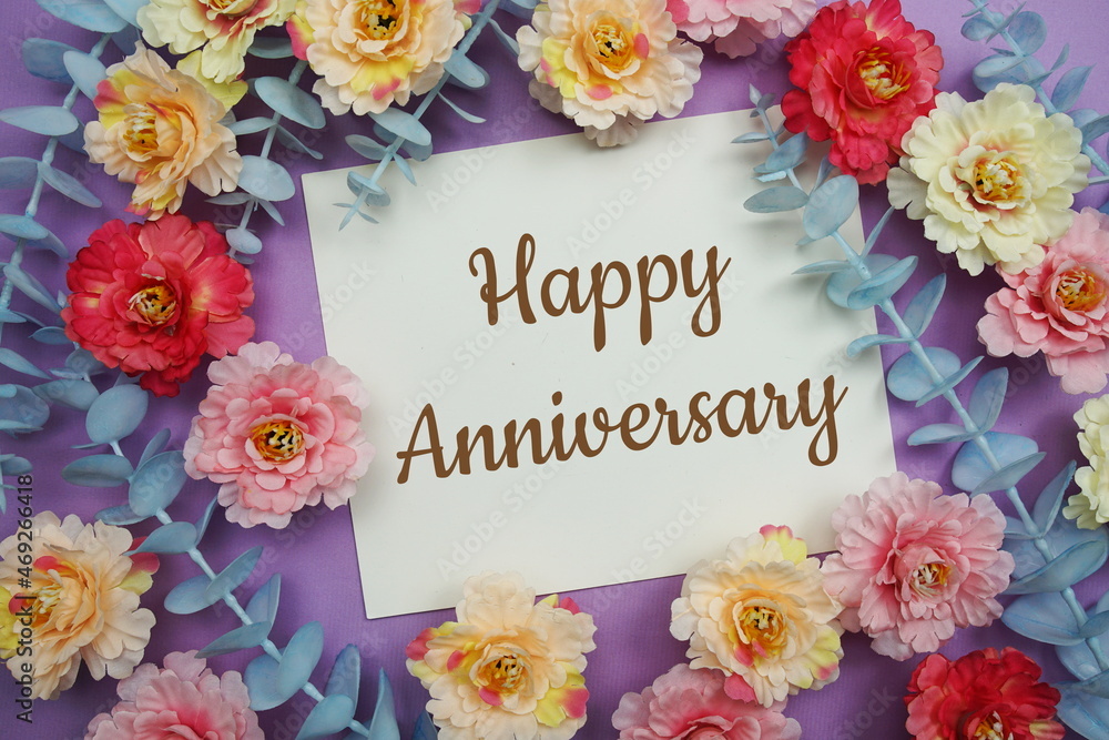 Happy Anniversary typography text and flower decorate on purple background Happy Anniversary typography text and flower decorate on purple background
