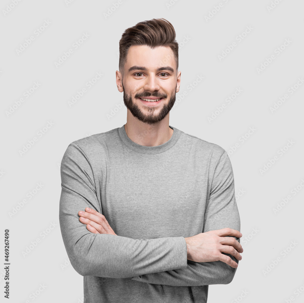 Portrait of handsome smiling young man with folded arms. Smiling joyful cheerful men with crossed hands isolated studio shot. Portrait of handsome smiling young man with folded arms. Smiling joyful cheerful men with crossed hands isolated studio shot.