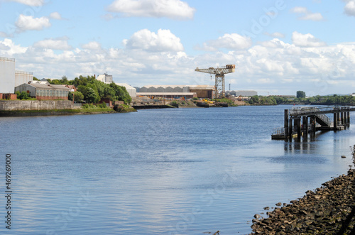 Deserted River View with Industrial Crane in Distance on Sunny Day