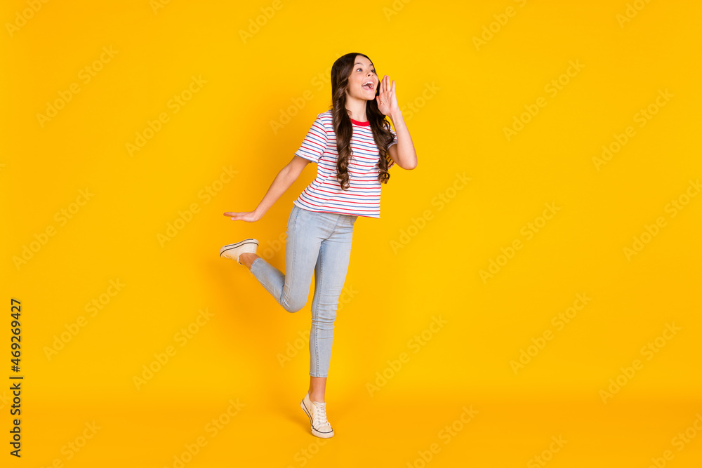 Full body profile side photo of young girl look empty space shout yell announcement news isolated over yellow color background Full body profile side photo of young girl look empty space shout yell announcement news isolated over yellow color background